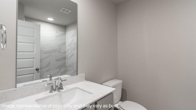 bathroom with toilet, vanity, and visible vents