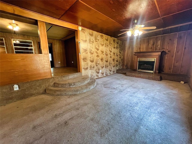 unfurnished living room featuring carpet flooring and wood walls