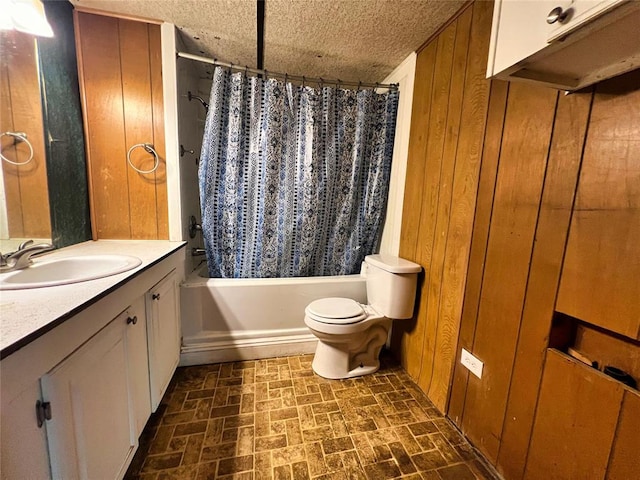 full bathroom with vanity, wood walls, shower / bath combination with curtain, toilet, and a textured ceiling