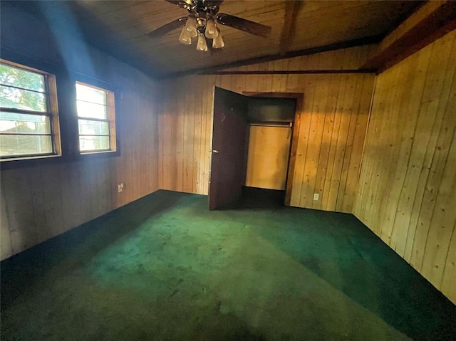 carpeted spare room with lofted ceiling with beams, ceiling fan, and wooden walls