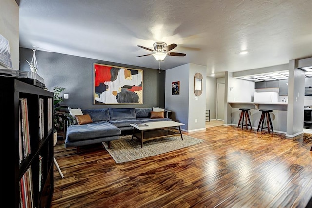 living room featuring ceiling fan and hardwood / wood-style floors