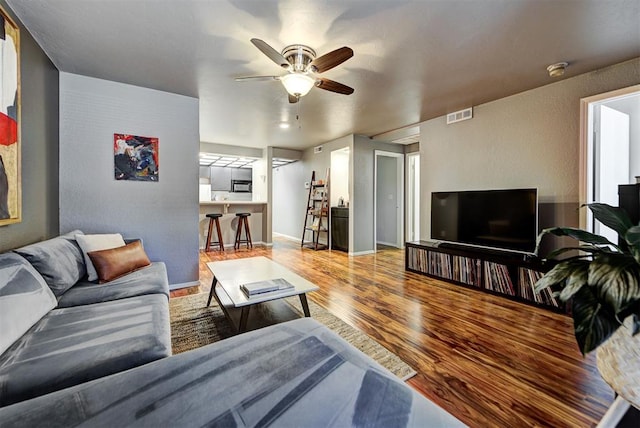 living room with ceiling fan and light wood-type flooring