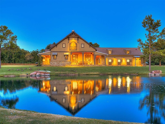 pool at dusk with a lawn and a water view