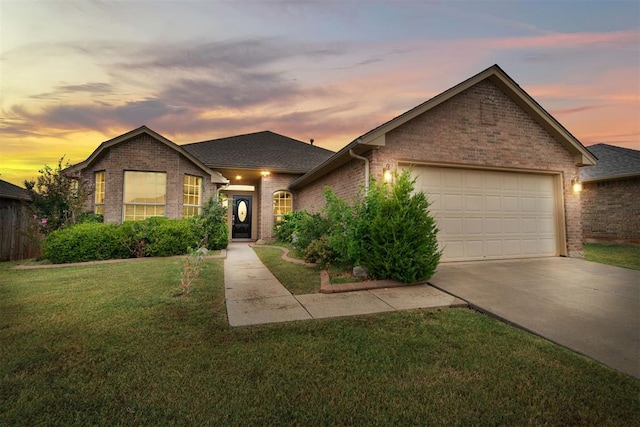 ranch-style home with a garage and a yard