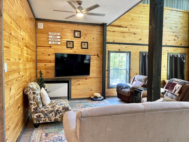 living room with hardwood / wood-style flooring, ceiling fan, and wooden walls