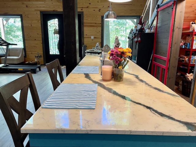 dining space with hardwood / wood-style floors and wood walls