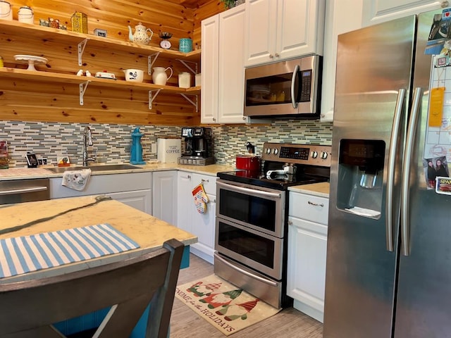 kitchen featuring white cabinets, stainless steel appliances, tasteful backsplash, and sink