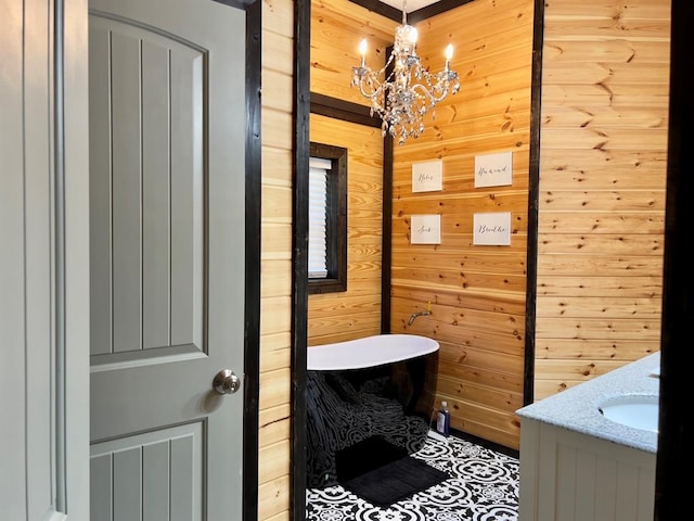 bathroom featuring vanity, a tub, wooden walls, and a chandelier