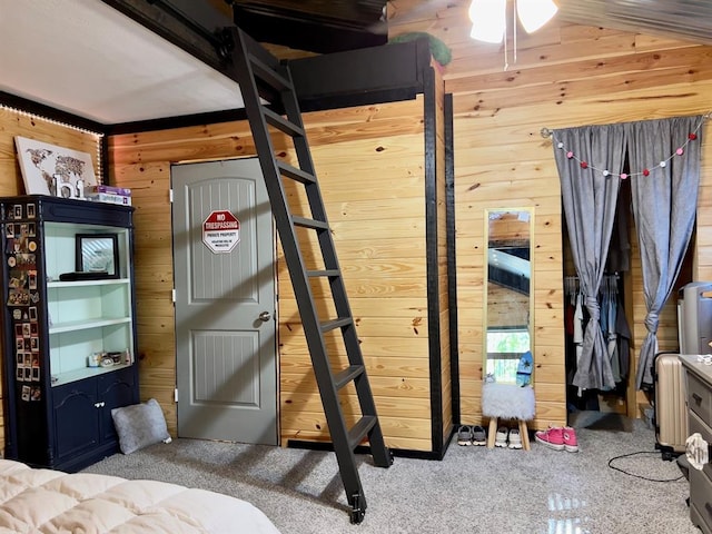 bedroom with wooden walls, carpet floors, and vaulted ceiling