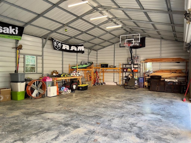 garage with a workshop area, wood walls, and a carport