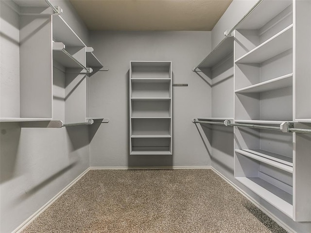 walk in closet featuring dark carpet