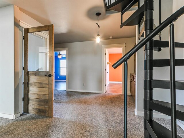 interior space with carpet flooring and ceiling fan