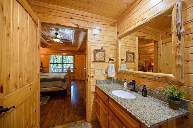 bathroom with hardwood / wood-style flooring, ceiling fan, wood ceiling, and wooden walls