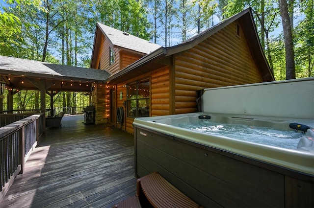 view of property exterior featuring a hot tub and a deck