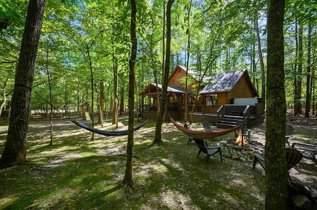 view of jungle gym with an outdoor fire pit and a wooden deck