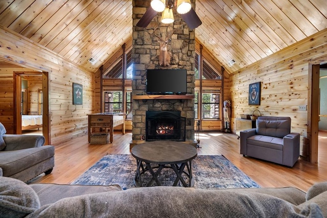 living room with high vaulted ceiling, light hardwood / wood-style flooring, a wealth of natural light, and wooden walls