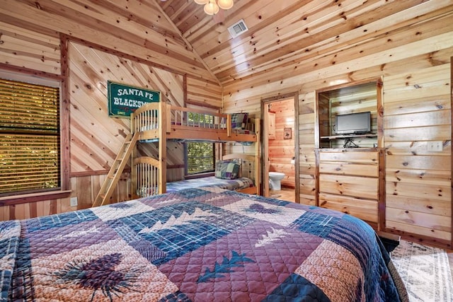 bedroom featuring wooden walls and high vaulted ceiling