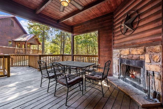 deck with ceiling fan and an outdoor stone fireplace