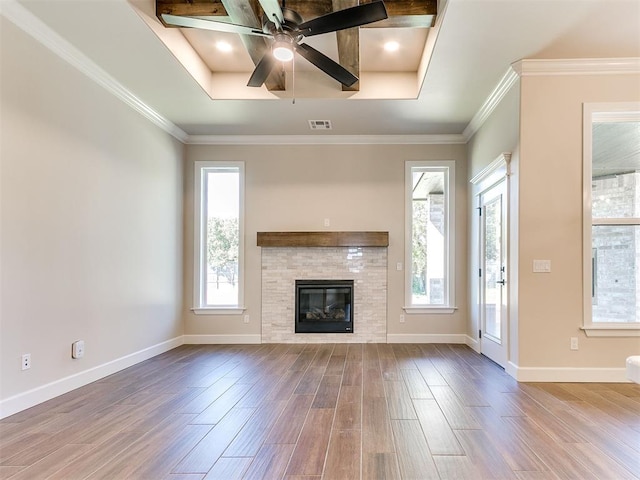 unfurnished living room with a raised ceiling, plenty of natural light, and wood-type flooring