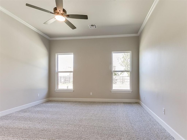 carpeted spare room with plenty of natural light, crown molding, and ceiling fan