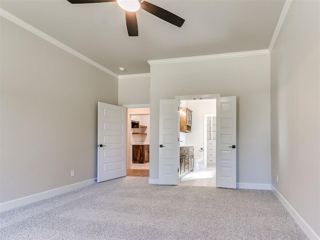 unfurnished bedroom with connected bathroom, ceiling fan, crown molding, and light colored carpet