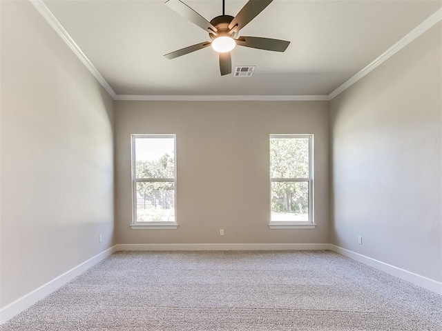 carpeted spare room featuring a wealth of natural light, crown molding, and ceiling fan