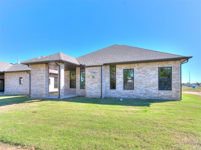 rear view of house featuring a lawn and a patio area