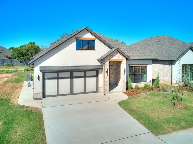 view of front of home featuring central AC unit, a garage, and a front lawn