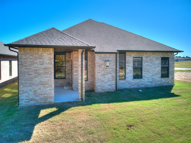 back of house with a yard and a patio