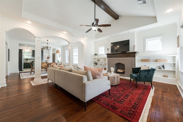 living room featuring vaulted ceiling with beams, dark wood-type flooring, a healthy amount of sunlight, and ceiling fan with notable chandelier