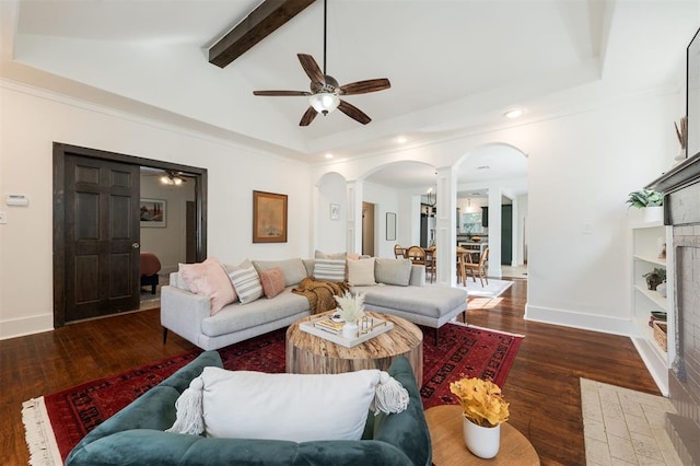 living room featuring vaulted ceiling with beams, dark hardwood / wood-style floors, ceiling fan, and decorative columns