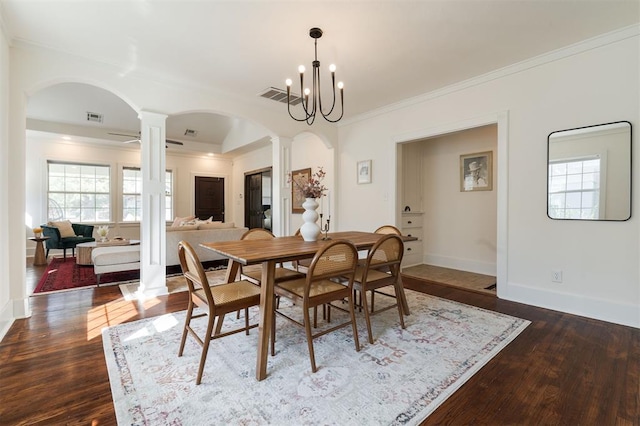 dining space featuring ornamental molding, an inviting chandelier, and dark wood-type flooring