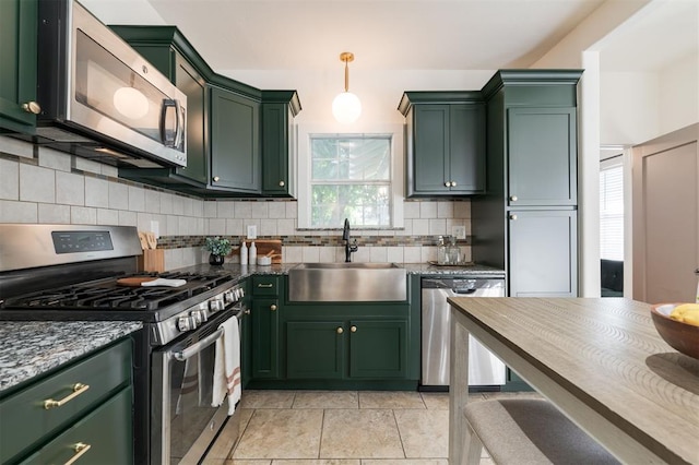 kitchen with backsplash, sink, stainless steel appliances, and green cabinetry