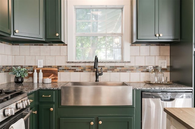 kitchen with decorative backsplash, green cabinets, sink, and stainless steel appliances