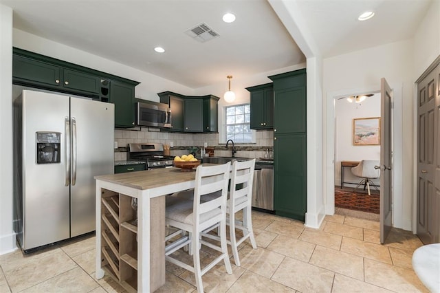 kitchen with decorative backsplash, light tile patterned floors, stainless steel appliances, and decorative light fixtures