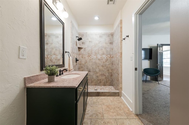 bathroom featuring vanity and tiled shower