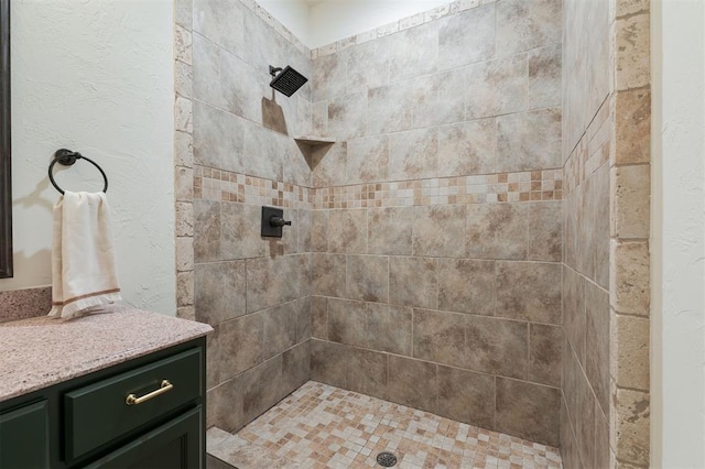 bathroom featuring vanity and tiled shower