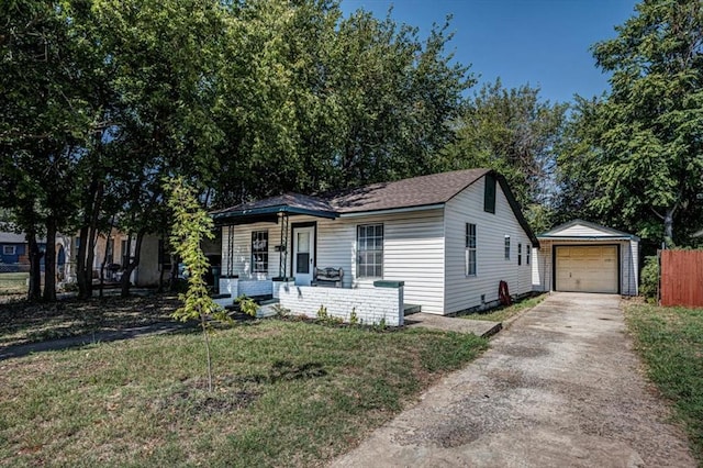 view of front of home featuring a porch, a garage, an outbuilding, and a front yard