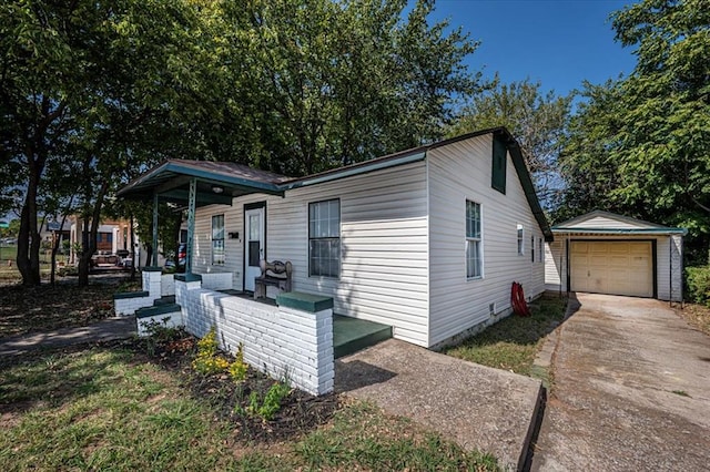 view of front of property featuring covered porch, a garage, and an outdoor structure