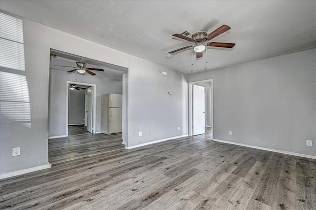 empty room with ceiling fan and wood-type flooring