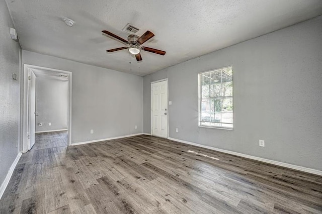 empty room featuring ceiling fan, light hardwood / wood-style floors, and a textured ceiling