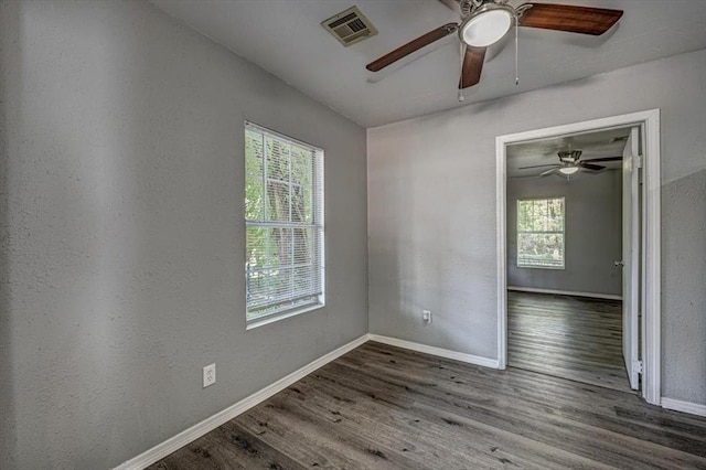 unfurnished room featuring plenty of natural light and dark wood-type flooring