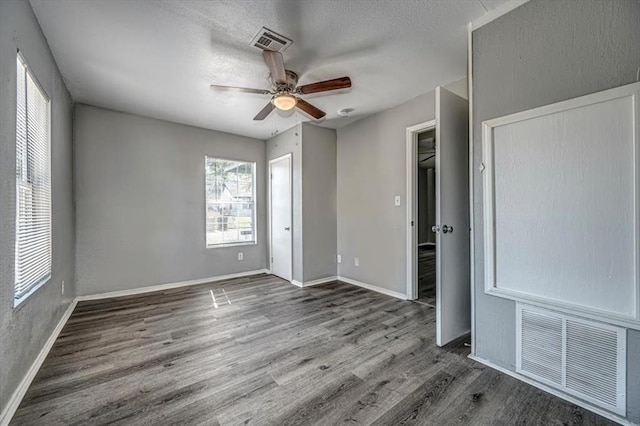 unfurnished bedroom with ceiling fan, dark wood-type flooring, and a textured ceiling