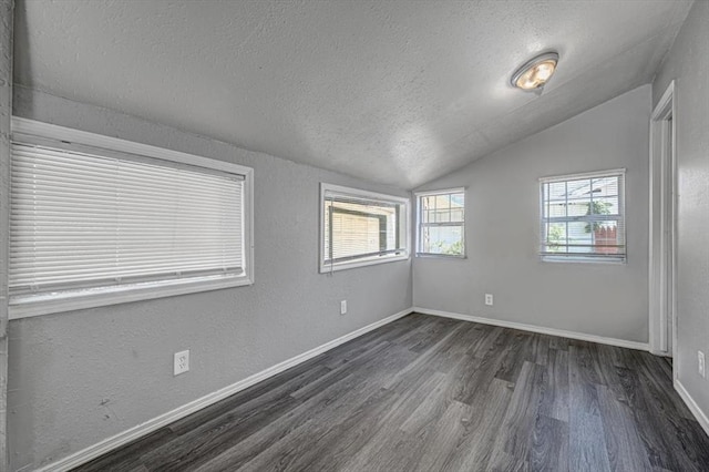 unfurnished room with a textured ceiling, dark hardwood / wood-style floors, and lofted ceiling