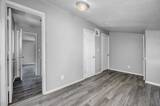 unfurnished bedroom featuring dark hardwood / wood-style flooring and a textured ceiling