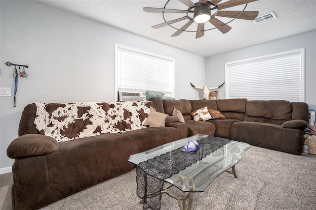 carpeted living room featuring ceiling fan, cooling unit, and a textured ceiling