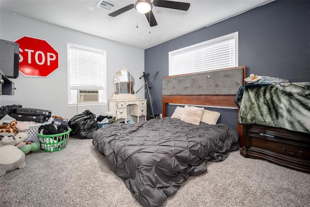 carpeted bedroom featuring ceiling fan, cooling unit, and a textured ceiling