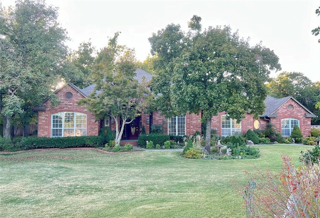 obstructed view of property with brick siding and a front lawn