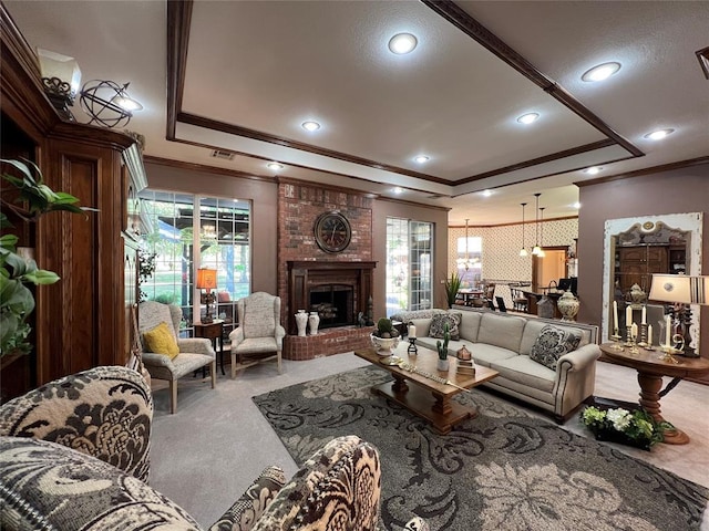 carpeted living area featuring a fireplace, a tray ceiling, and ornamental molding