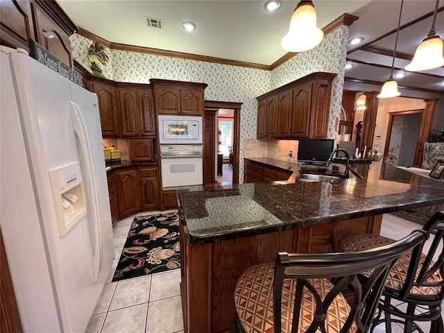 kitchen with white appliances, wallpapered walls, visible vents, a peninsula, and crown molding